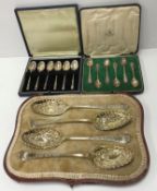 A cased set of four silver berry spoons with embossed floral decoration to the bowls and engraved