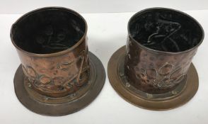 A pair of Arts & Crafts copper wine bottle coasters with embossed stylised floral decoration,