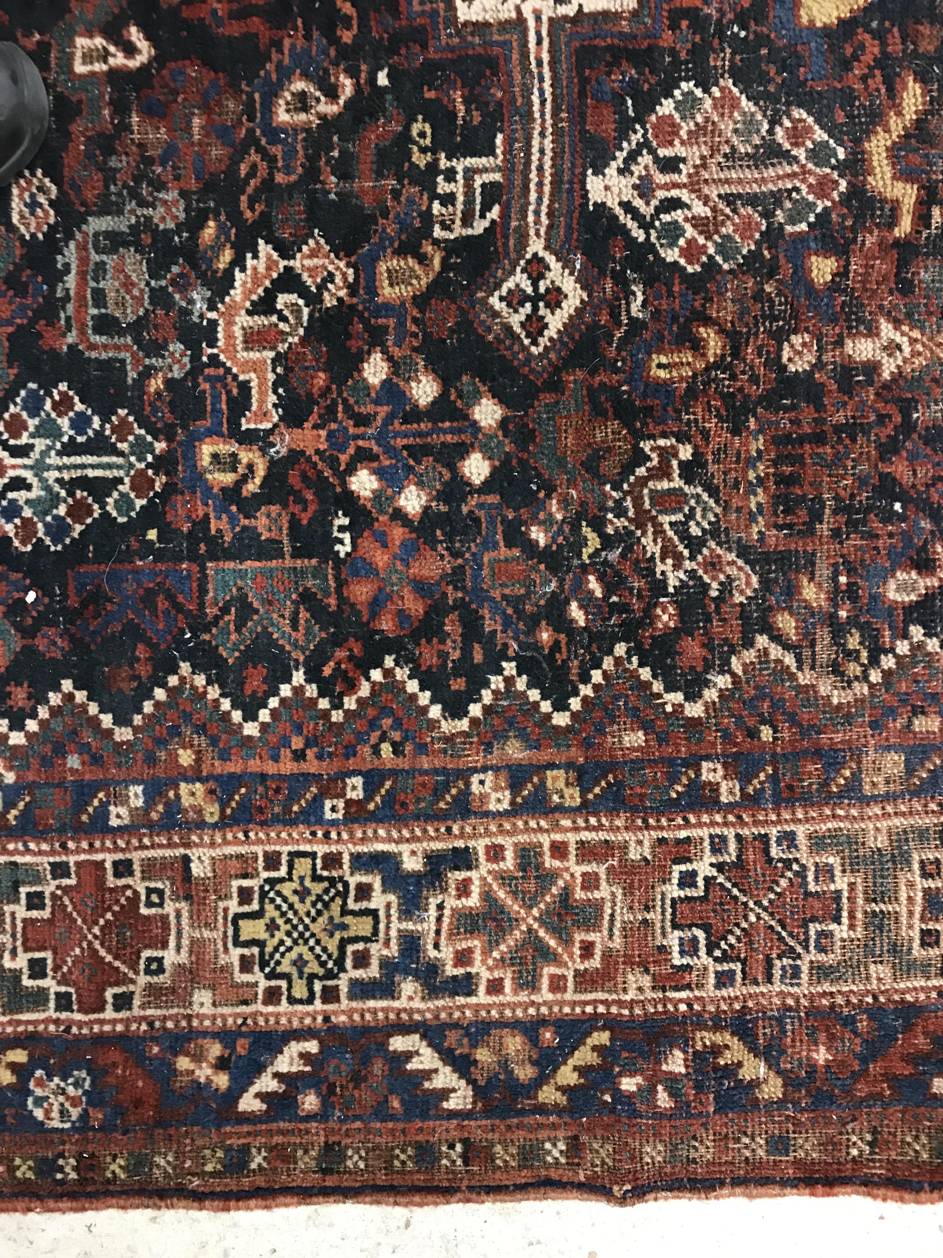A Persian carpet, the central panel set with repeating medallions on a dark blue ground, - Image 34 of 93