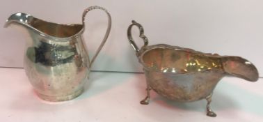 A George V silver cream jug of bellied form with reeded decoration to edge and acanthus set handle