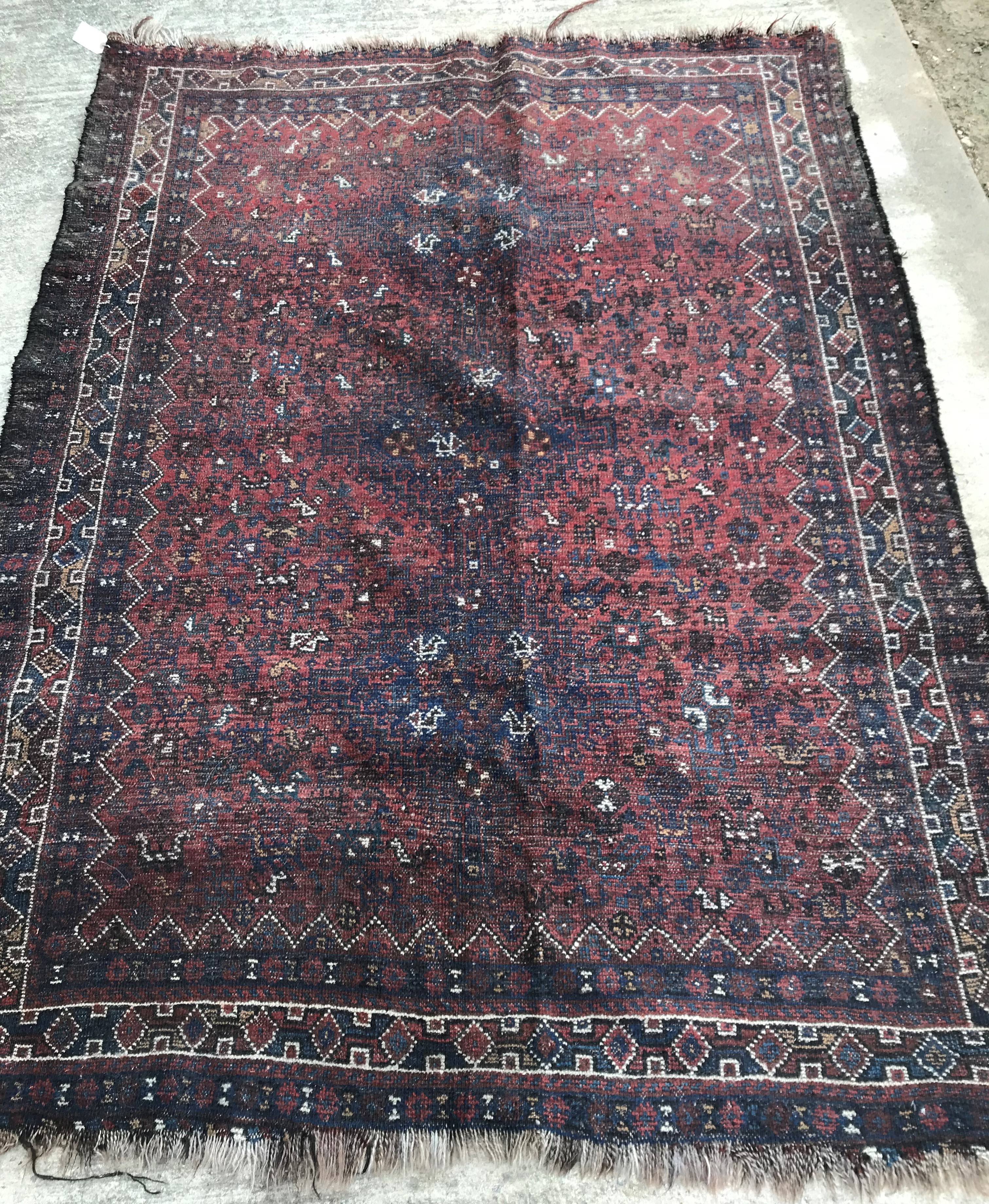 An early to mid-20th Century Persian red ground rug with repeating lozenge medallion decoration to - Image 4 of 7