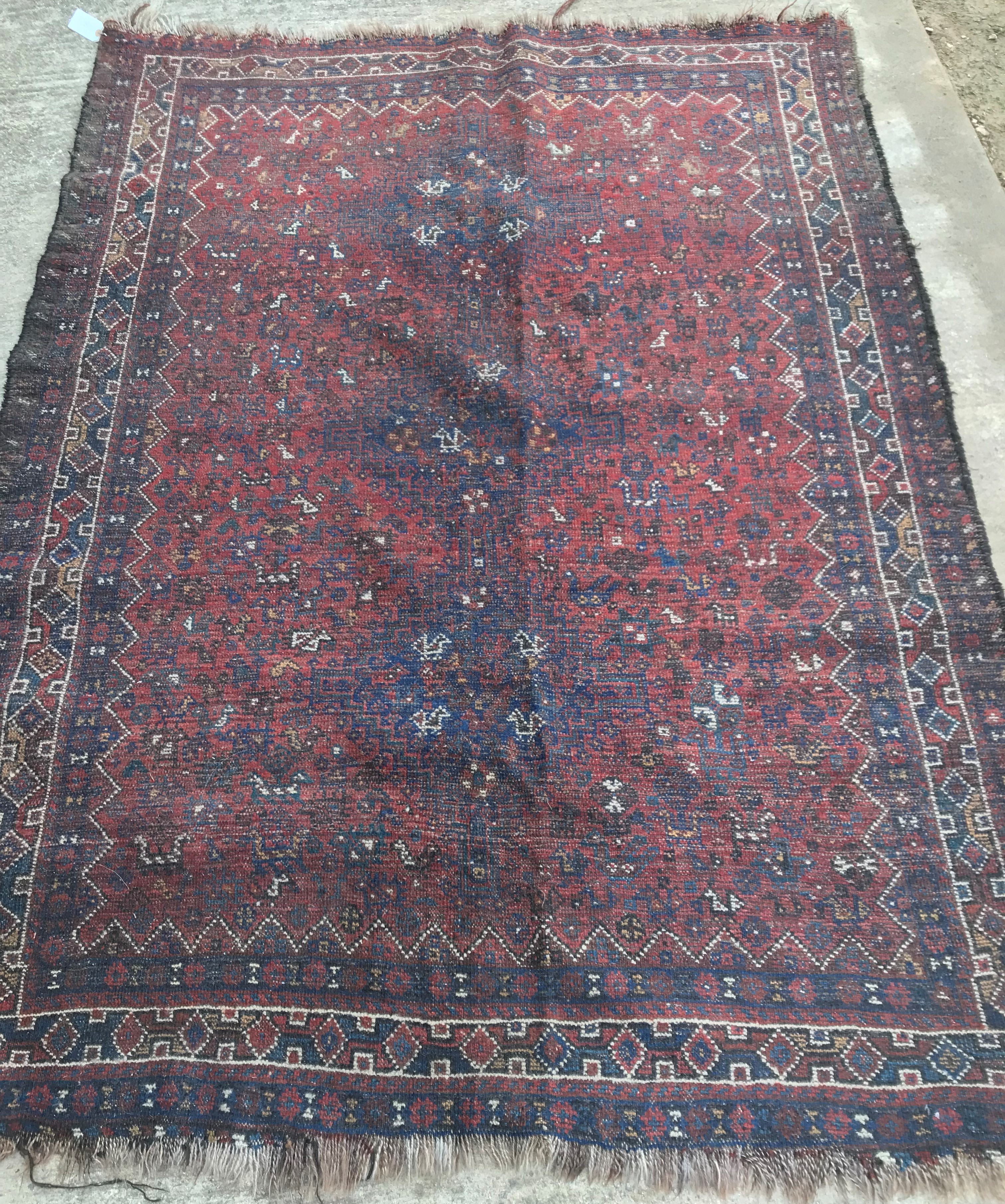 An early to mid-20th Century Persian red ground rug with repeating lozenge medallion decoration to - Image 5 of 7