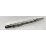 A silver mounted propelling pencil with engine turned decoration on hexagonal barrel (by Johnson,