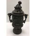 A cast metal bronzed urn with bacchanalian cherub and ram decoration,