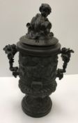 A cast metal bronzed urn with bacchanalian cherub and ram decoration,