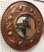 A circa 1900 copper framed circular wall mirror in the Arts and Crafts taste with leaf and berry