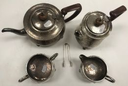 A George V beaten silver four piece tea set, raised on four paw feet (by J B Chatterley & Sons,