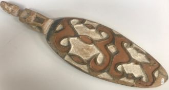 A Papua New Guinea carved and painted shield with figure surmount 77 cm long