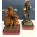 A 20th Century carved oak model of two men in overcoats, mounted on a velvet covered plinth base,