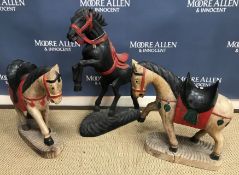A decorative carved wooden and painted horse figure with red bridle and saddle 76 cm high together
