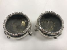 A pair of Victorian silver open salts of cauldron form with lotus leaf decorated rims,