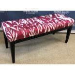 A modern red and white buttoned upholstered dressing stool on ebonised square tapered supports,