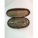 A 19th Century parquetry and mother of pearl inlaid etui of oval form opening to reveal a fitted