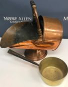 A copper coal scuttle of helmet form together with a brass saucepan with iron handle