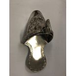 A South American white metal stirrup slipper with embossed floral decoration stamped "Peru 925" to