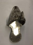 A South American white metal stirrup slipper with embossed floral decoration stamped "Peru 925" to