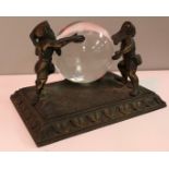 A bronze mounted study of "Two gnomes holding a fortune teller's crystal ball",