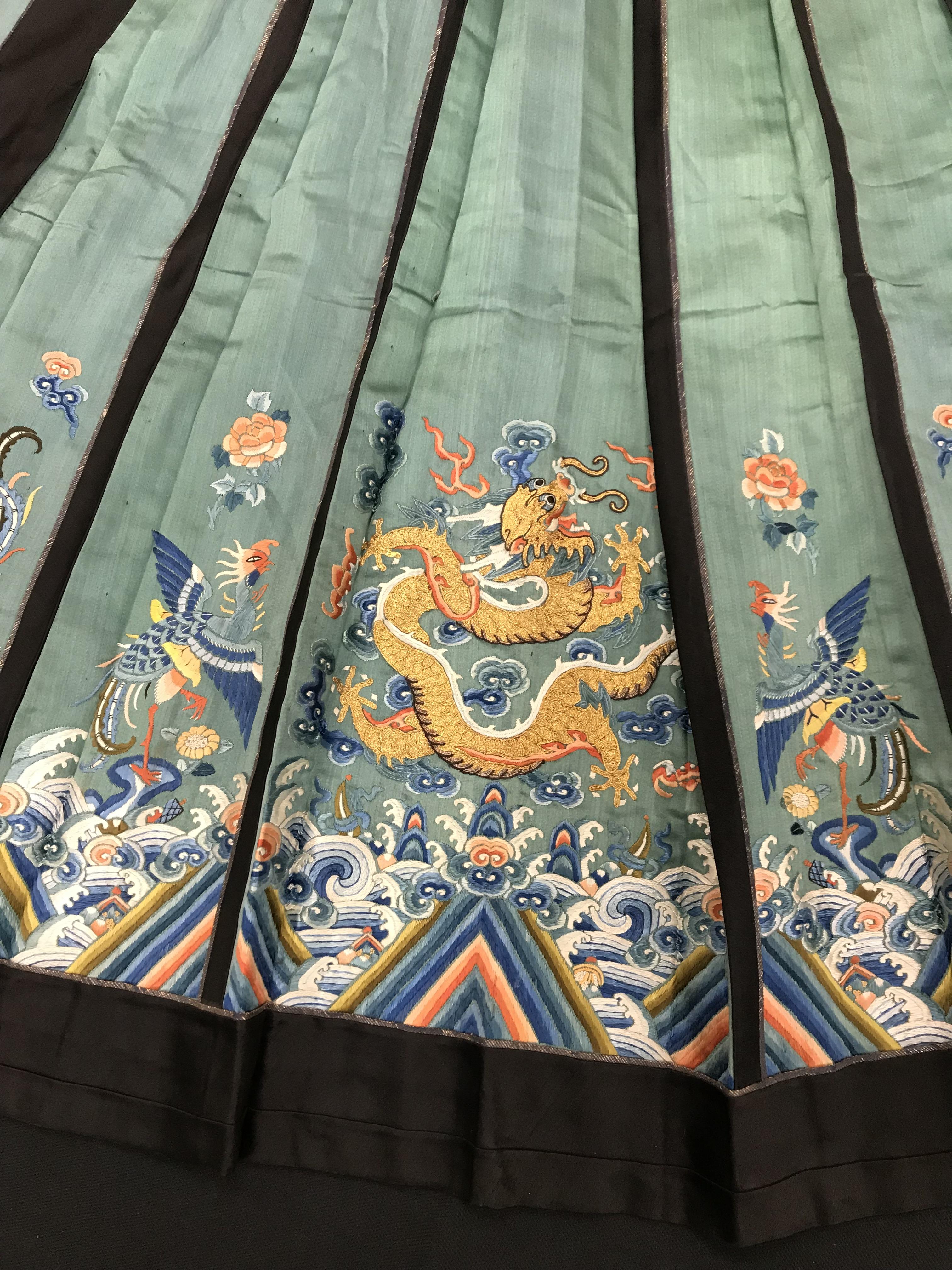 A Chinese teal silk skirt with black borders and a peach waistband, silk panels embroidered in blue, - Image 13 of 69