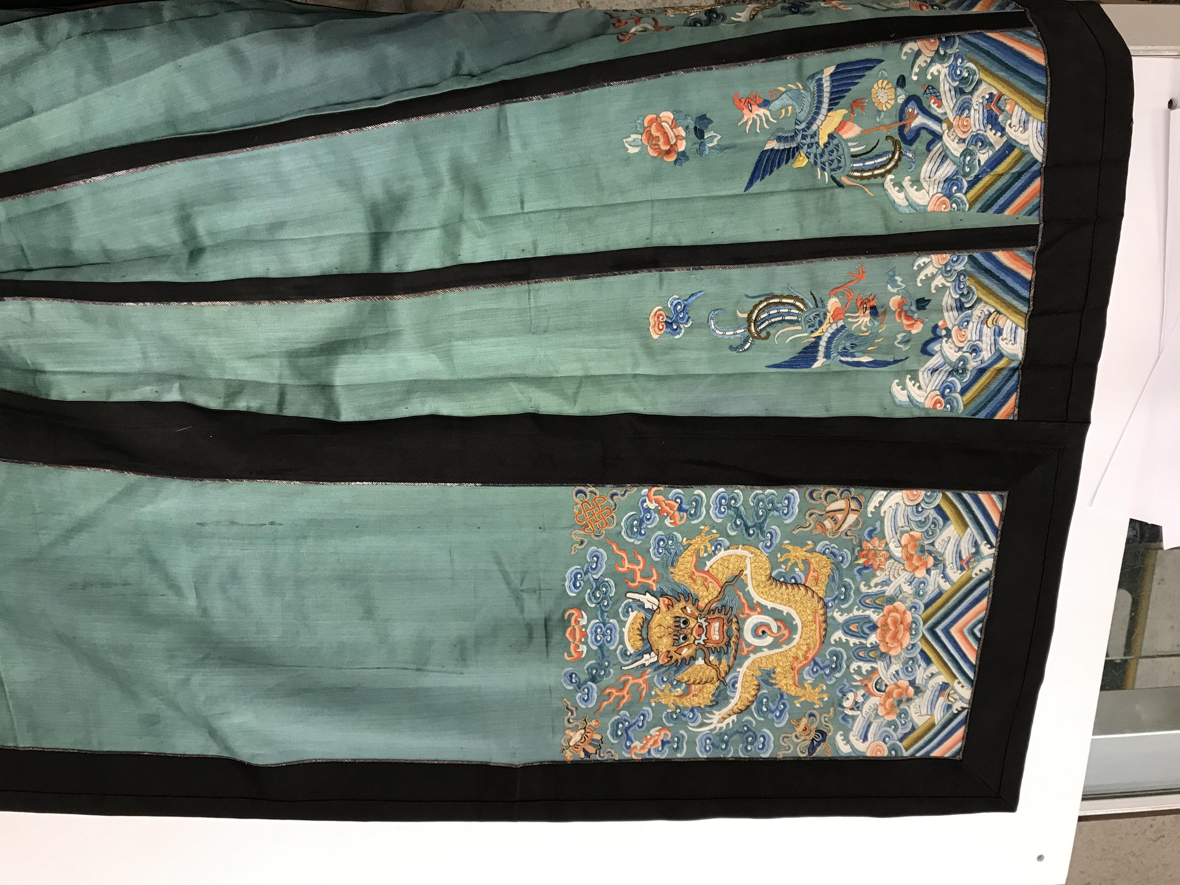 A Chinese teal silk skirt with black borders and a peach waistband, silk panels embroidered in blue, - Image 62 of 69