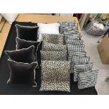 Two boxes containing five dark brown velvet cushions with cream piping,
