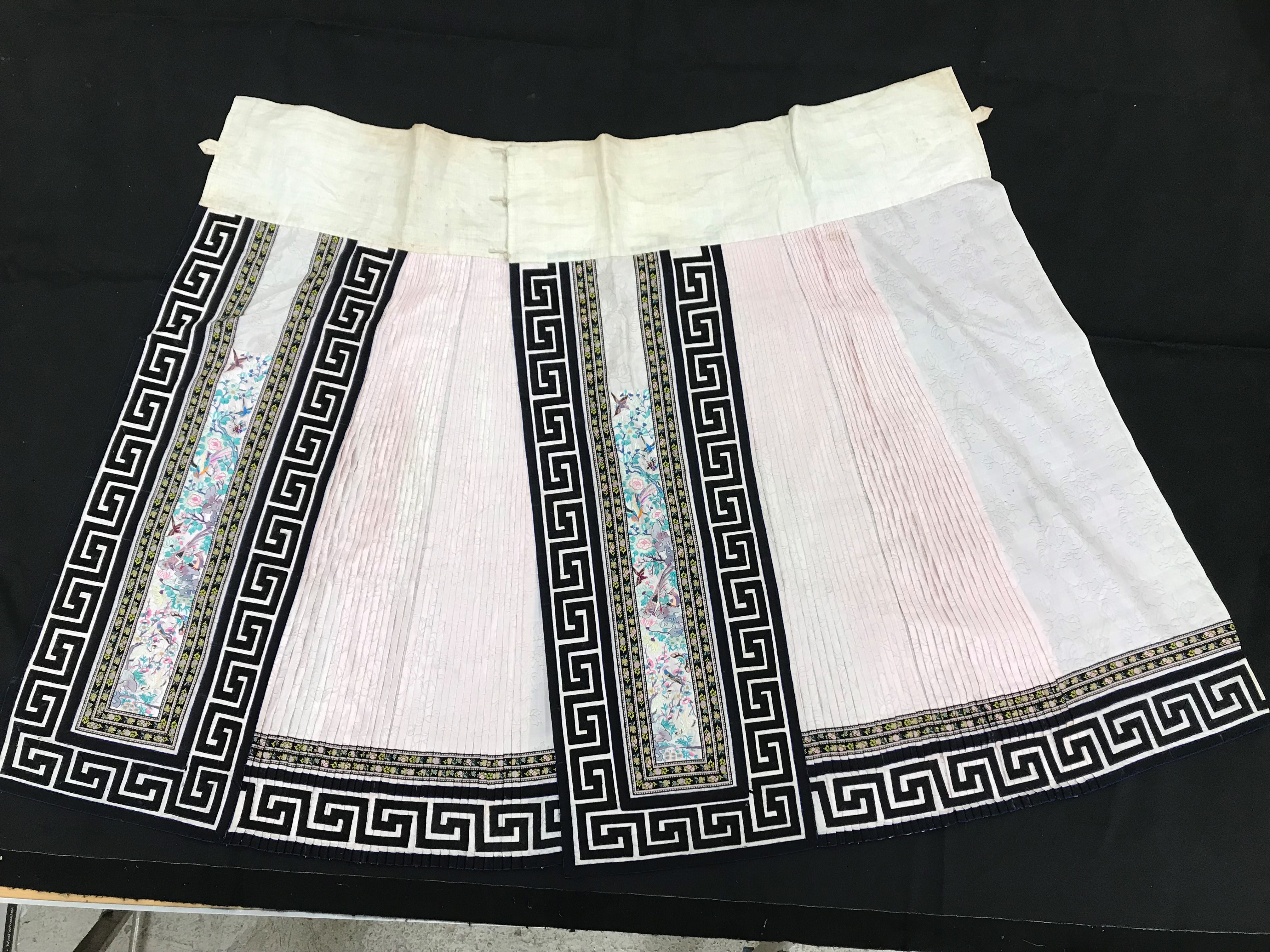 A Chinese silk skirt in two panels with a pink background overlaid with borders of Greek key type