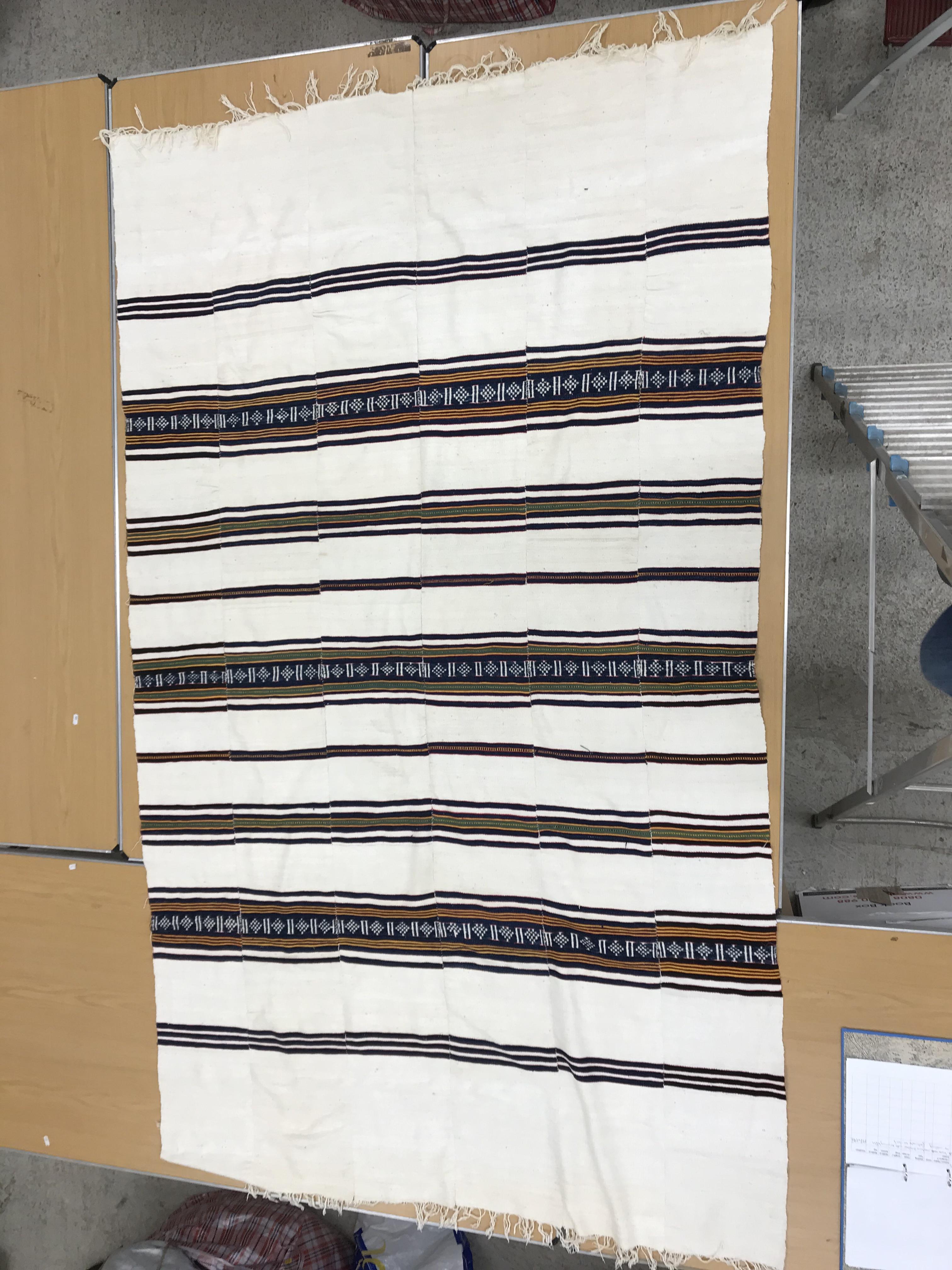 A mid 20th Century Fulani blanket in cream with blue and yellow stripes constructed of hand woven