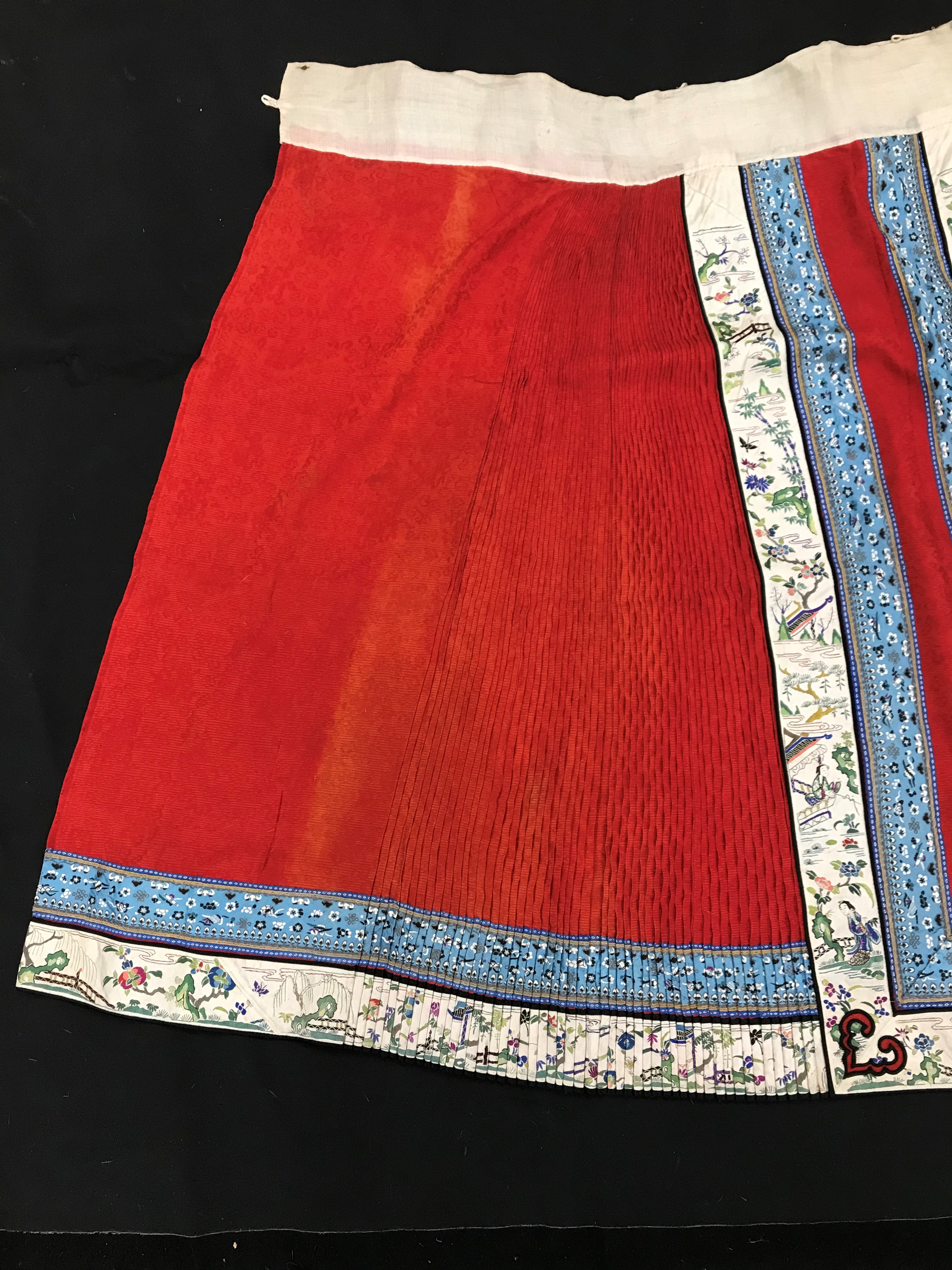 A Chinese red finely pleated silk skirt with blue and cream overlaid silk bands heavily embroidered - Image 2 of 31