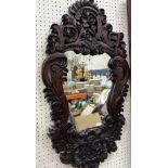 A modern Indonesian type hardwood framed mirror with all over scrolling foliate decoration 88.