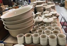 A large collection of oatmeal glazed pottery dinner wares bearing potter's mark impressed "R"