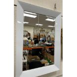 A modern rectangular wall mirror with white glass frame and bevelled edged mirror plate 109.