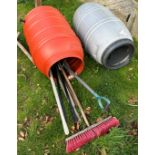 Two plastic water butts, one containing a collection of garden tools to include spade,