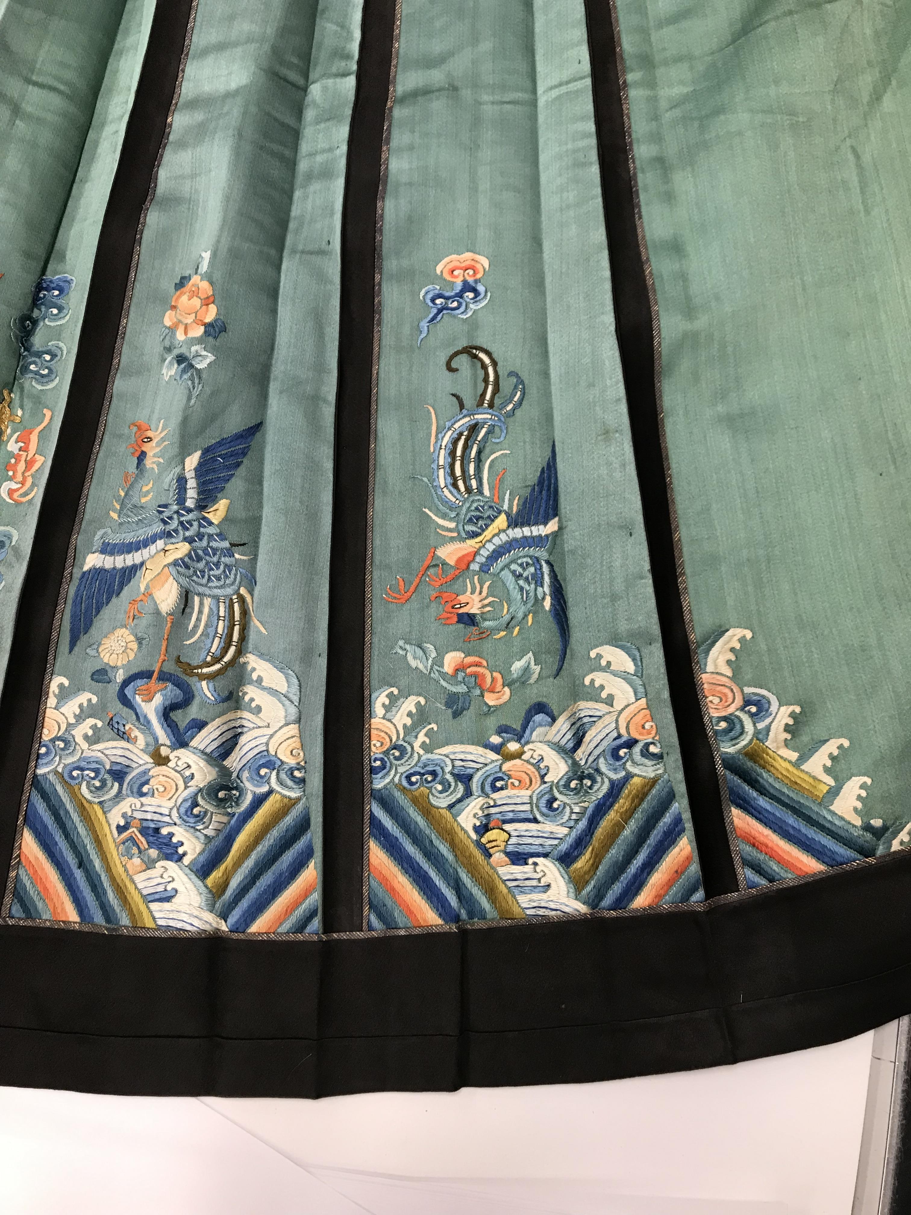 A Chinese teal silk skirt with black borders and a peach waistband, silk panels embroidered in blue, - Image 55 of 69
