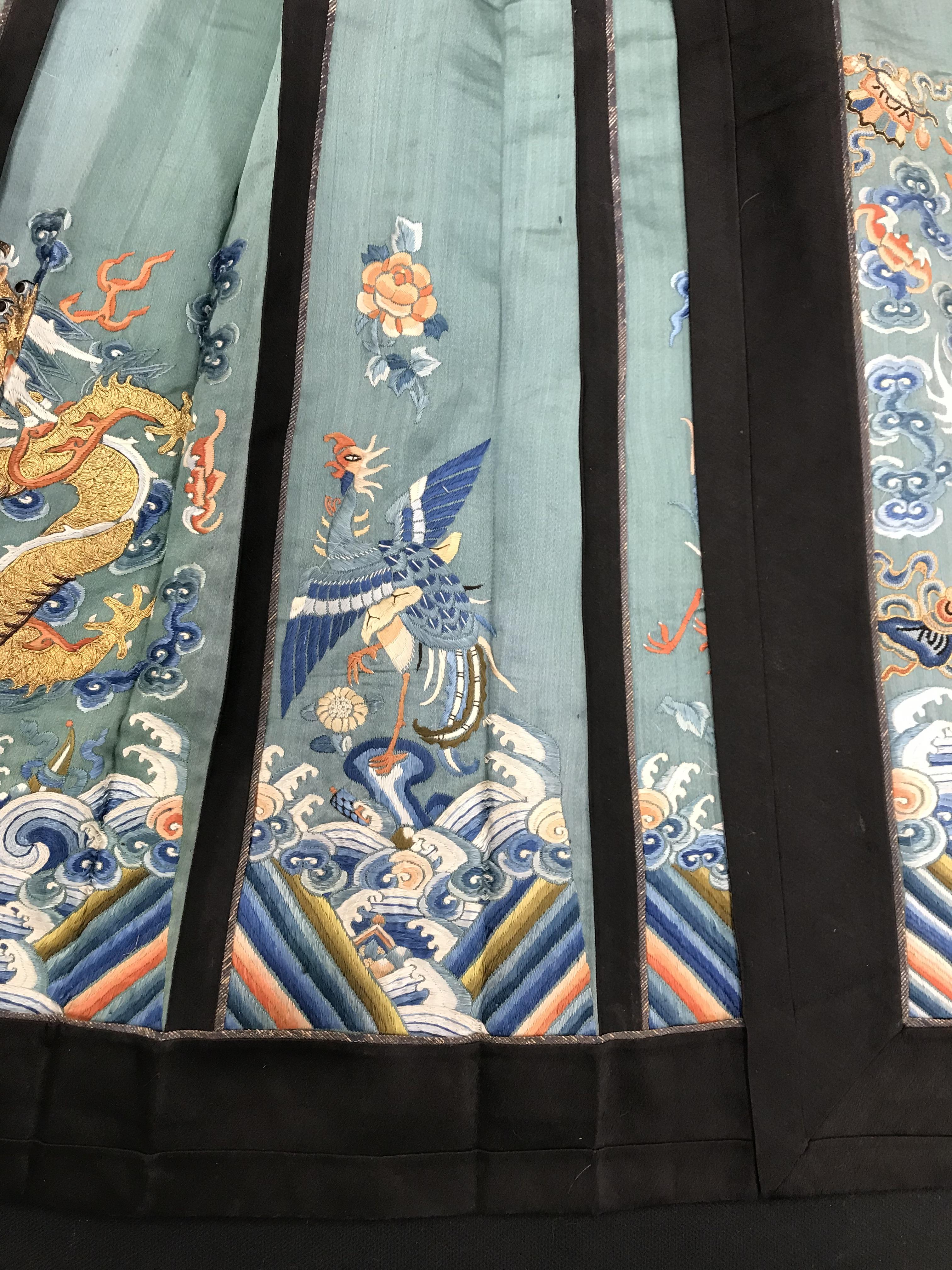 A Chinese teal silk skirt with black borders and a peach waistband, silk panels embroidered in blue, - Image 8 of 69