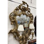 A 19th Century girandole mirror with scrolling foliate decoration around a shaped glass,