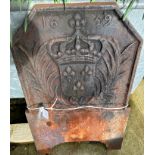 A cast iron fire back with crowned shield and crossed palm leaves decoration,