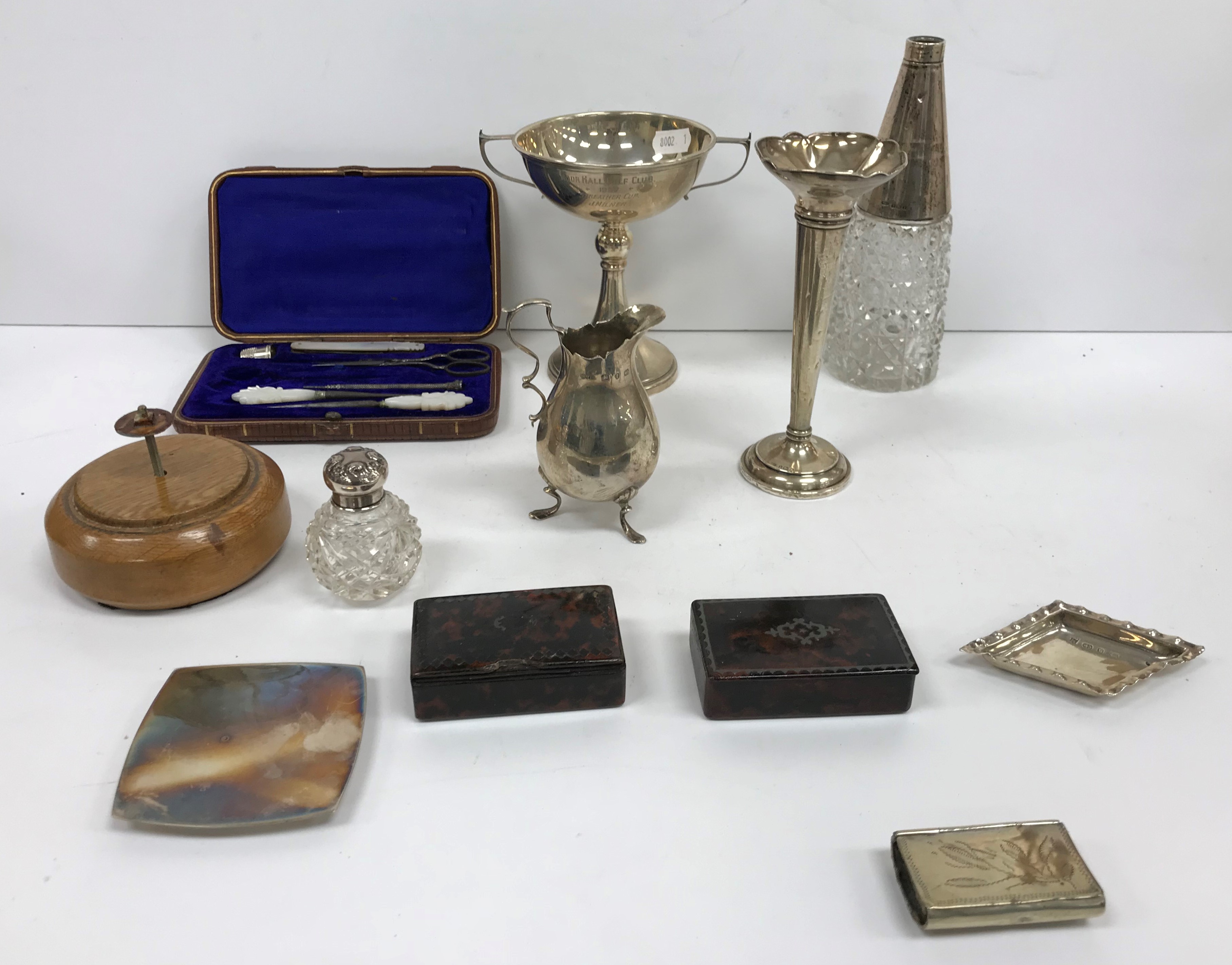 A box of small silver wares to include a baluster shaped cream jug on three scroll feet,