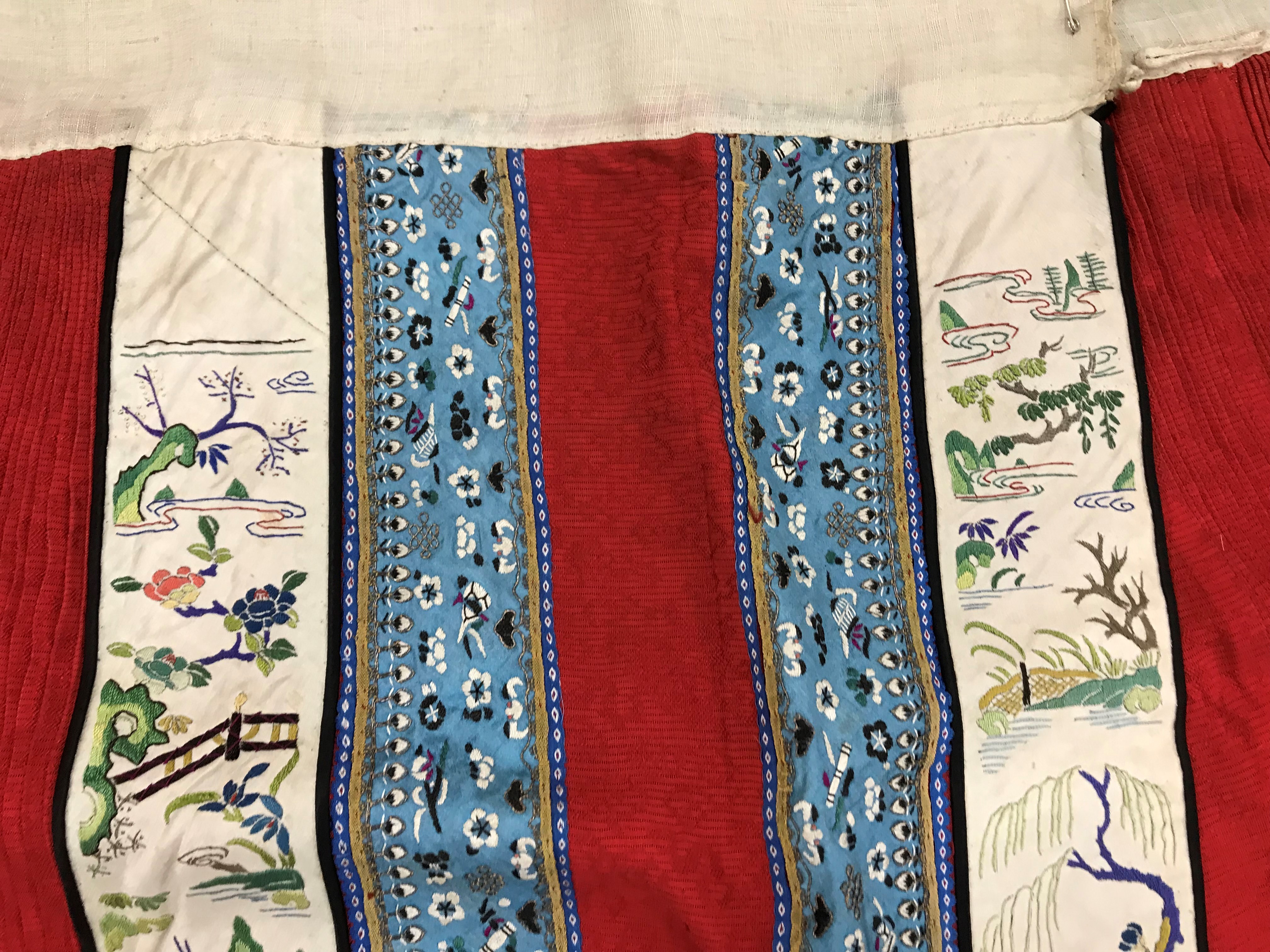 A Chinese red finely pleated silk skirt with blue and cream overlaid silk bands heavily embroidered - Image 17 of 31
