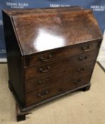 A George III mahogany bureau, the plain top over a plum pudding fall,