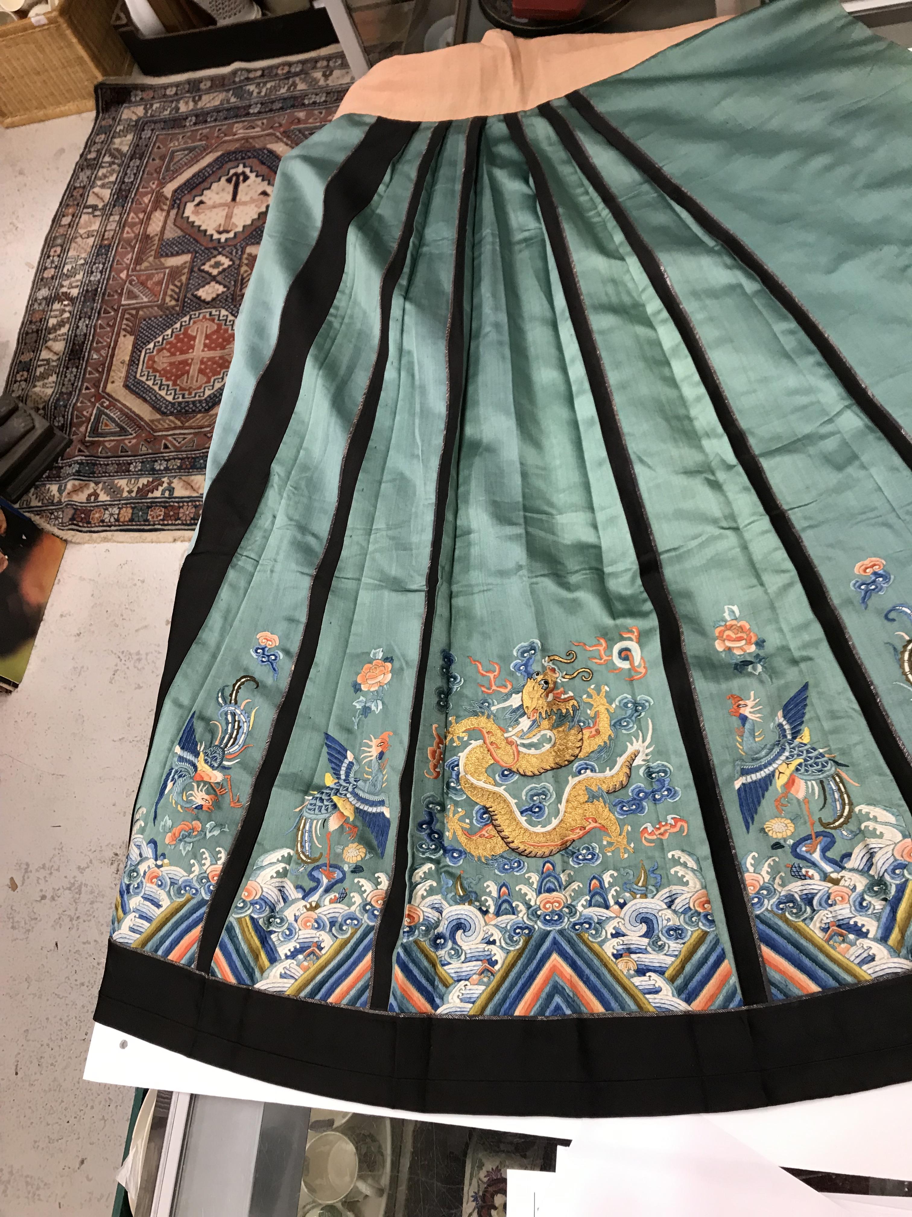 A Chinese teal silk skirt with black borders and a peach waistband, silk panels embroidered in blue, - Image 42 of 69