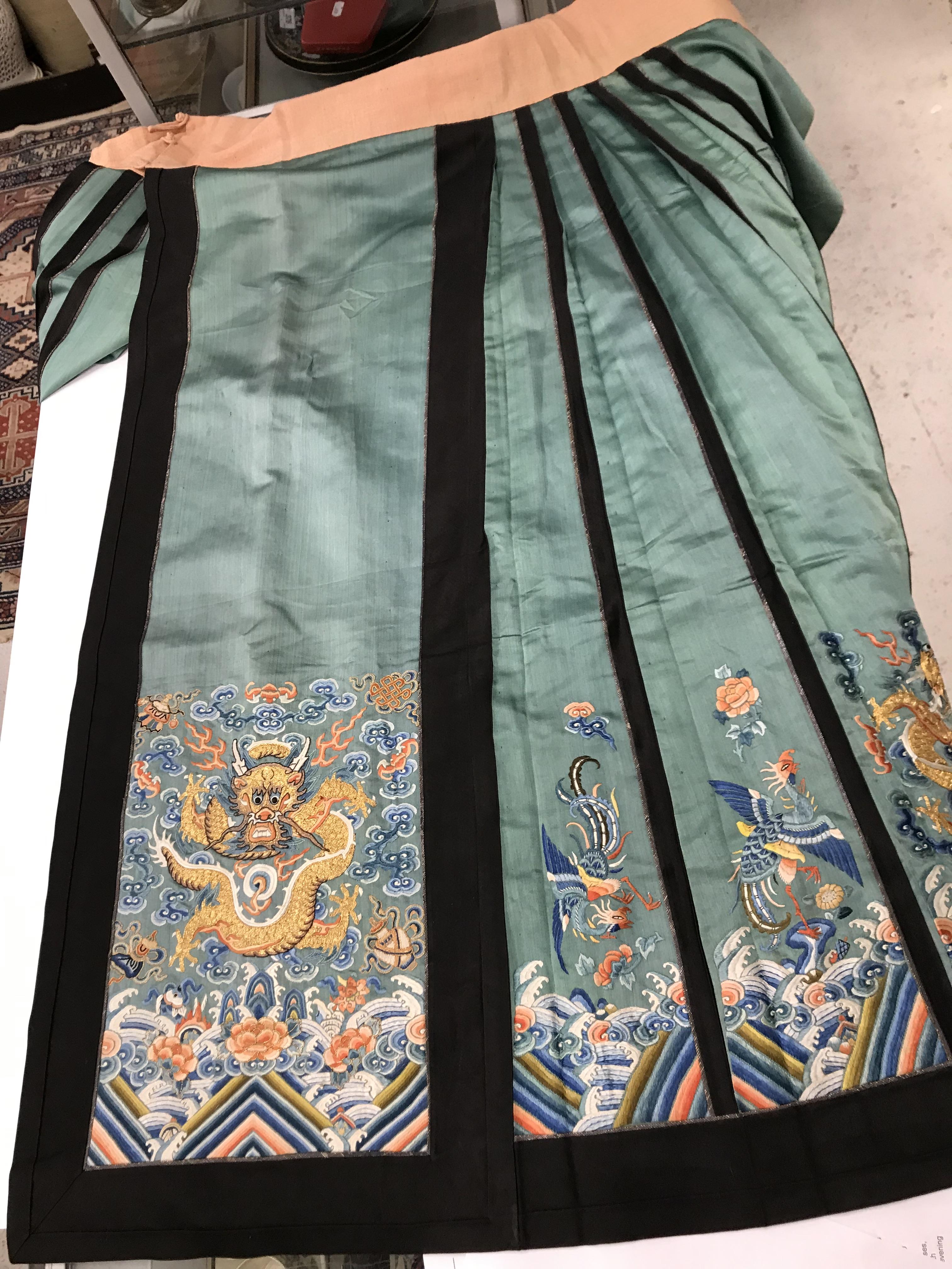 A Chinese teal silk skirt with black borders and a peach waistband, silk panels embroidered in blue, - Image 47 of 69