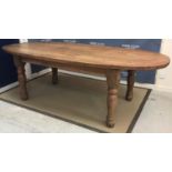 A pine oval dining table, the plank top on baluster turned supports,