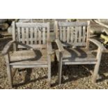 A pair of teak slatted garden arm chairs, each 67.