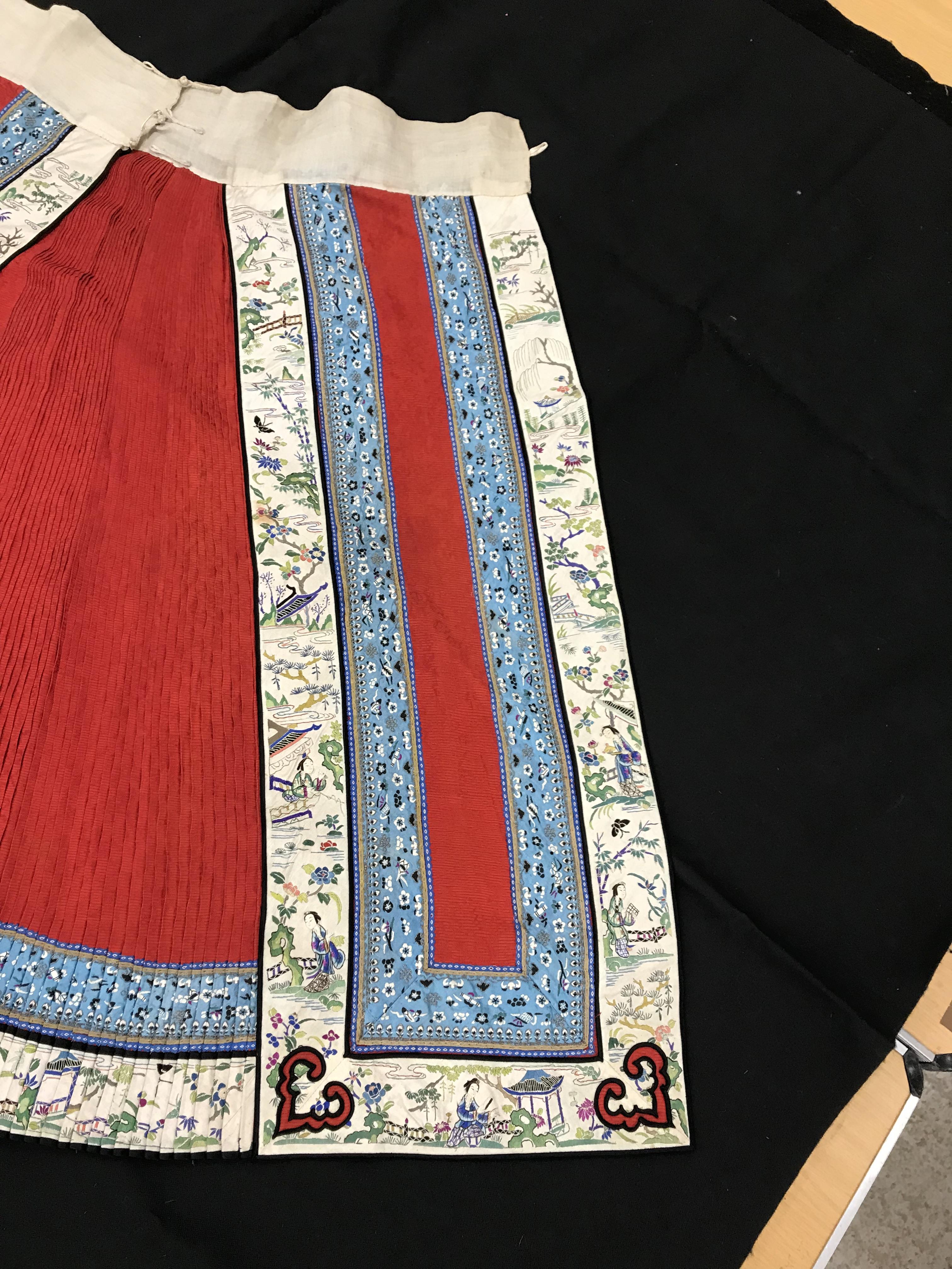 A Chinese red finely pleated silk skirt with blue and cream overlaid silk bands heavily embroidered - Image 5 of 31