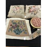 A box containing two tapestry cushions with floral design and fringing,