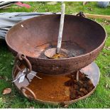 A cast iron and studded fire pit and stand with cover and wooden handled ladle, 75 cm diameter,