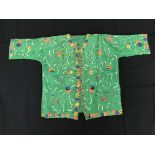 A Chinese green silk top with chain stitched foliate embroidery to the main body,