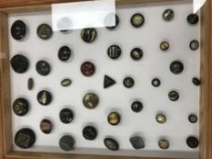 A frame containing a selection of bakelite and buttons in other materials,
