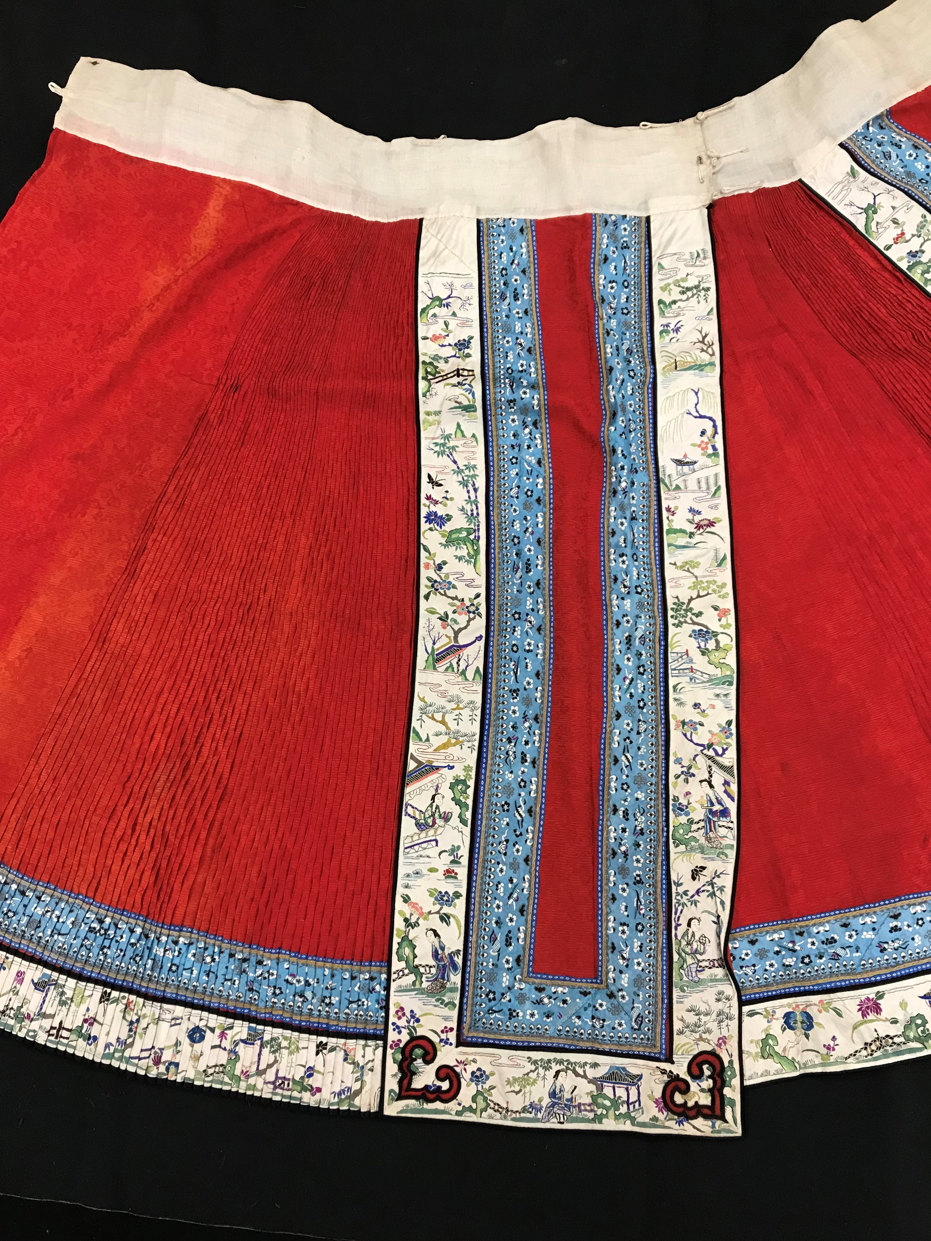 A Chinese red finely pleated silk skirt with blue and cream overlaid silk bands heavily embroidered - Image 3 of 31