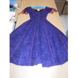 A 1960's Sybil Connolly ruched cocktail dress in blue with brown piped decoration and bow trim to