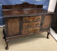 An early 20th Century mahogany serpentine fronted sideboard with three central drawers flanked by